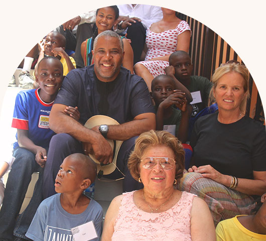 Robert F. Smith sitting with a group of children and adults