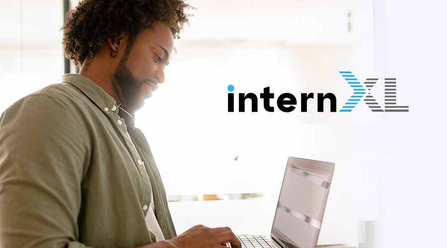 Image of a Black man in a collared button-down shirt working on a laptop situated next to the internXL logo