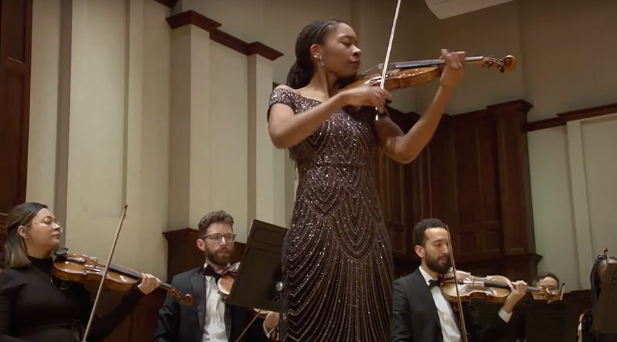 A violinist stands tall, showcasing her musical skills at a Sphinx Organization event