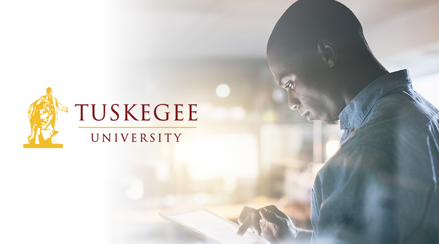 A Tuskegee University student reading a tablet in a classroom