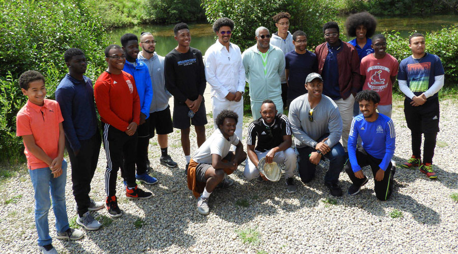 Robert F. Smith outdoors with a group of young people
