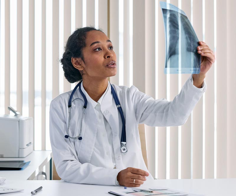 Black doctor examining an x-ray