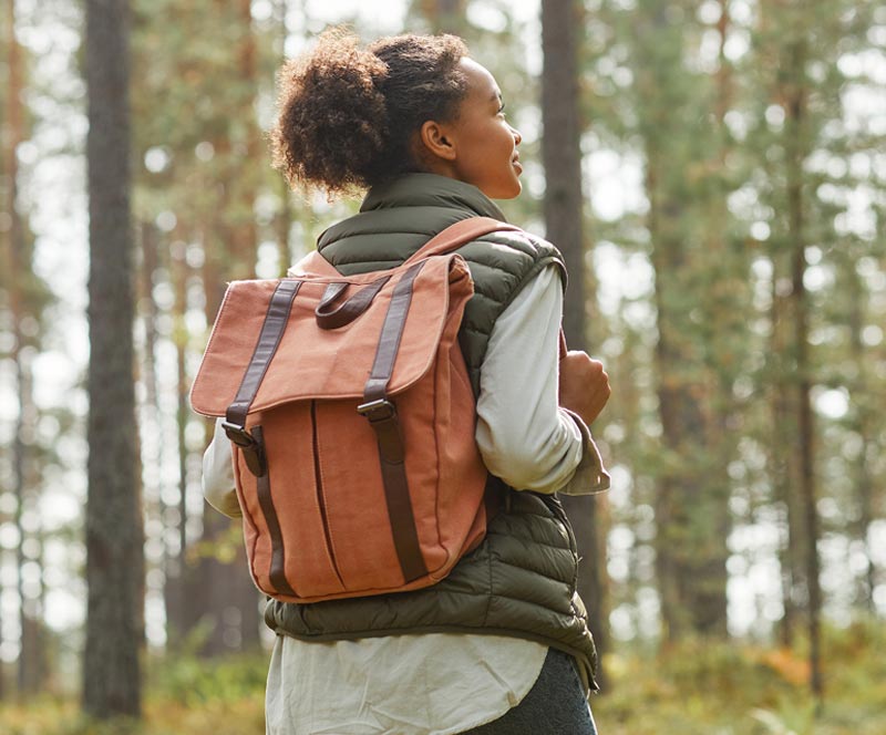 African American in the woods hiking wearing a backpack