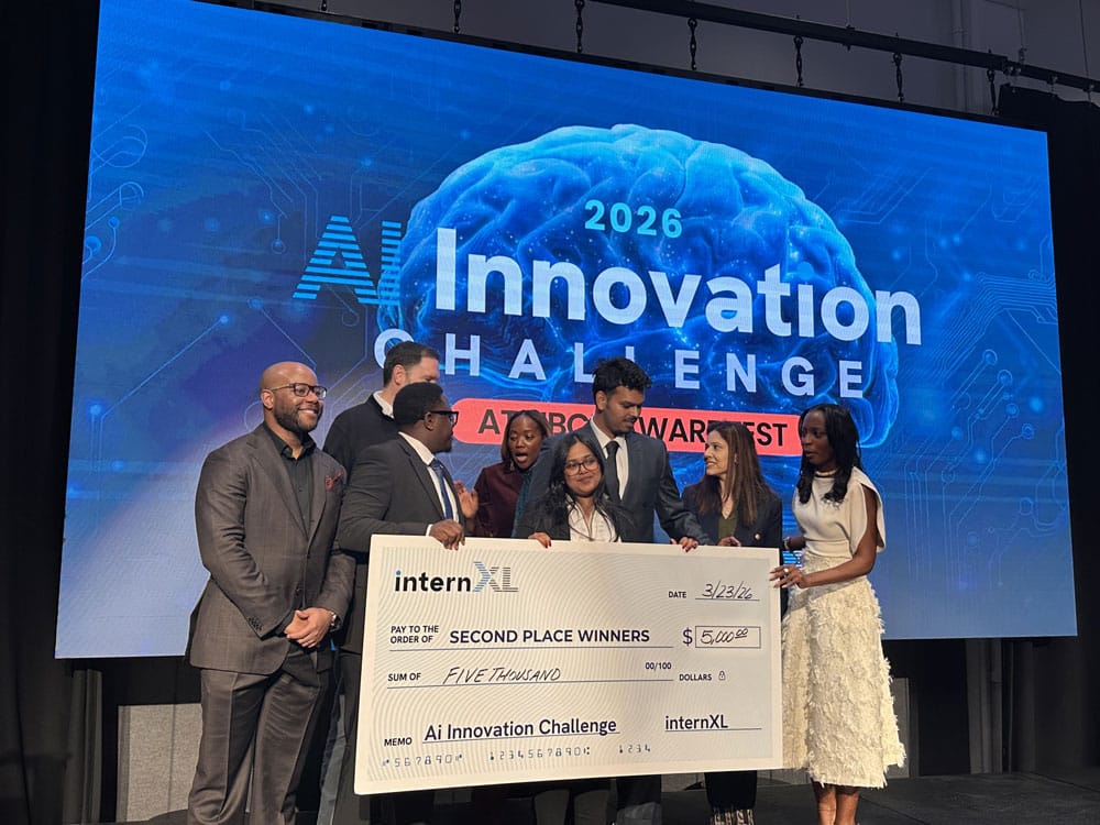 A group of students holding a check from internXL with a screen behind them that says 2026 AI Innovation Challenge.